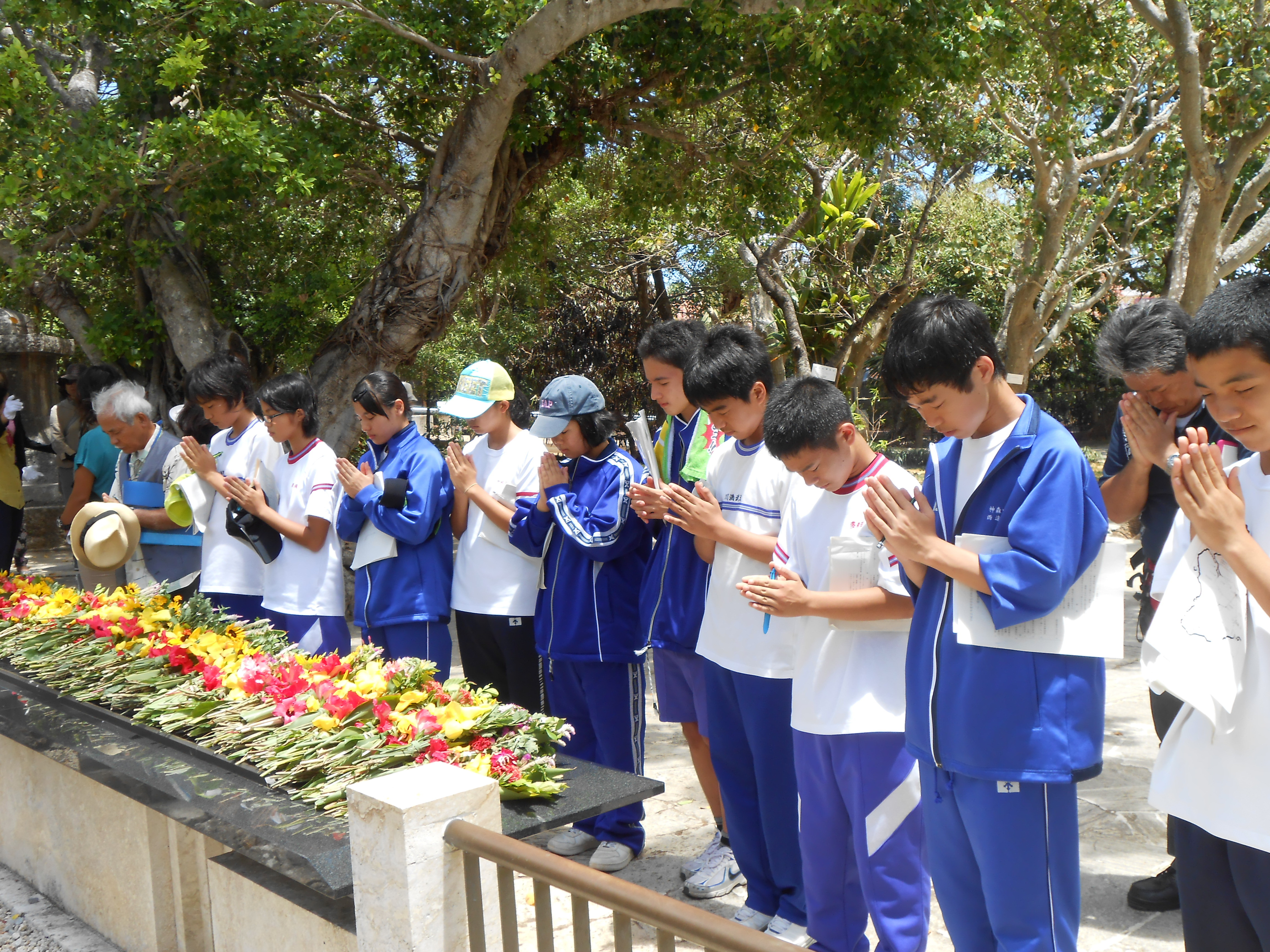 ひめゆりの塔で黙とうする団員